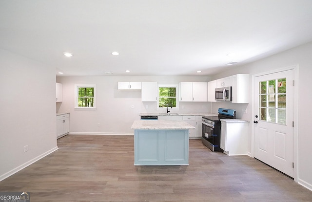 165 Dowdy Rd, Athens, GA 30606 - kitchen with appliances with stainless steel finishes, a sink, white cabinetry, light wood finished floors, and a center island