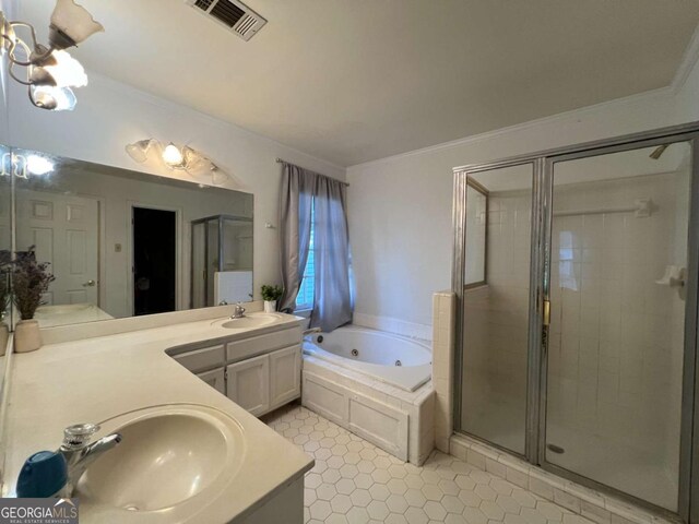 bathroom with a jetted tub, a stall shower, crown molding, double vanity, and tile patterned floors