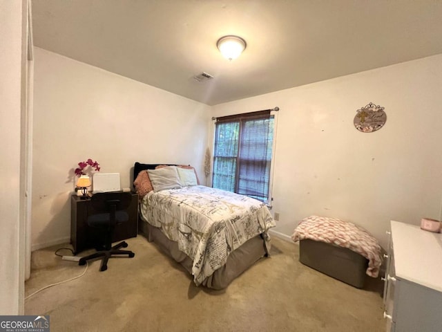 bedroom with light colored carpet and baseboards