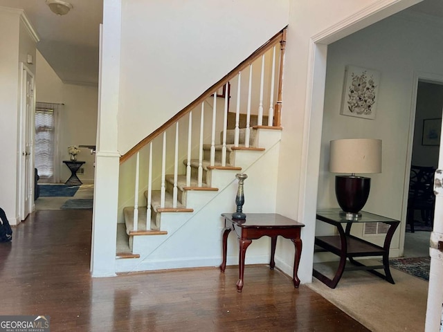 staircase with wood finished floors and baseboards
