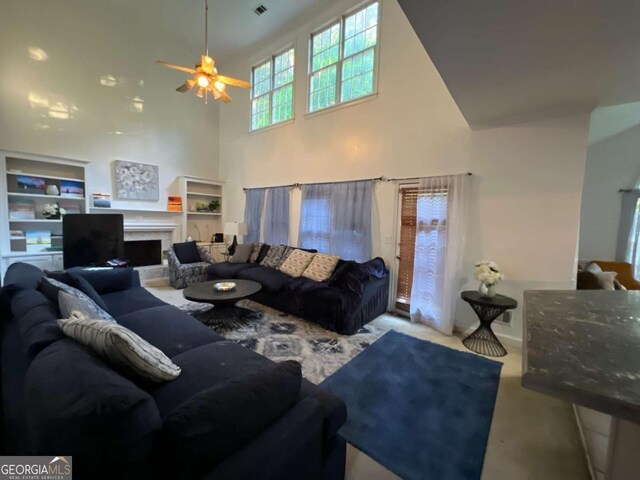 carpeted living room with a towering ceiling, a ceiling fan, and a fireplace