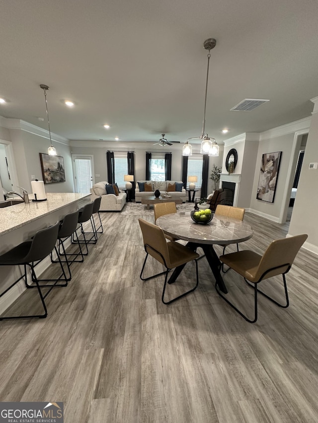 3006 Fairway Dr, Villa Rica, GA 30180 - dining space featuring wood finished floors, crown molding, a fireplace, recessed lighting, and a ceiling fan
