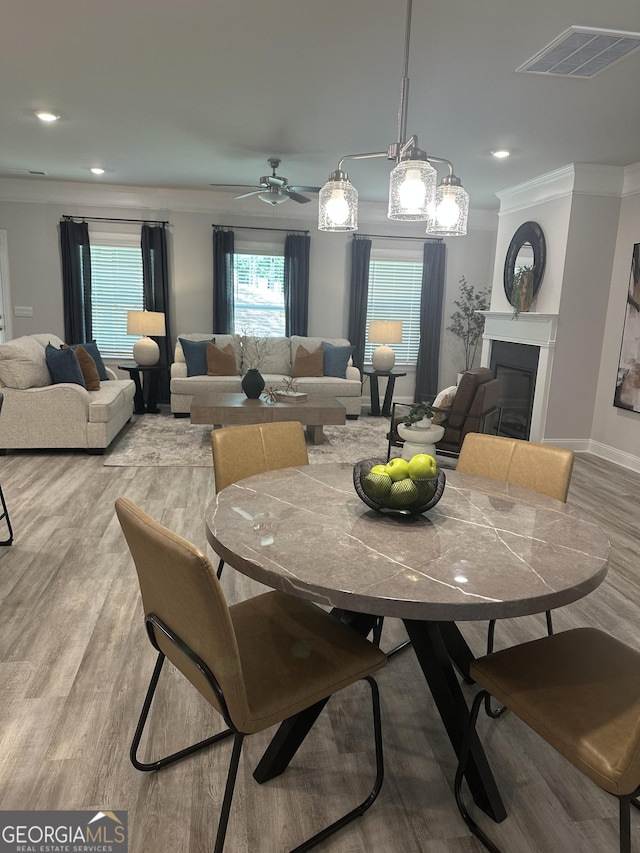 3006 Fairway Dr, Villa Rica, GA 30180 - dining room with crown molding, light wood finished floors, a glass covered fireplace, recessed lighting, and ceiling fan