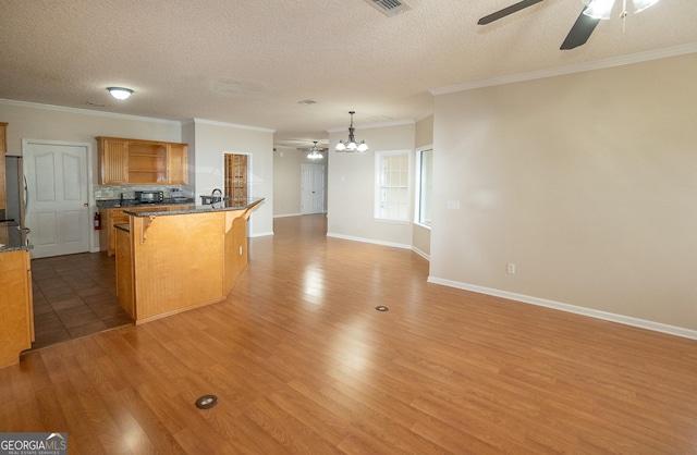 kitchen with open shelves, a chandelier, a kitchen bar, ceiling fan, and crown molding