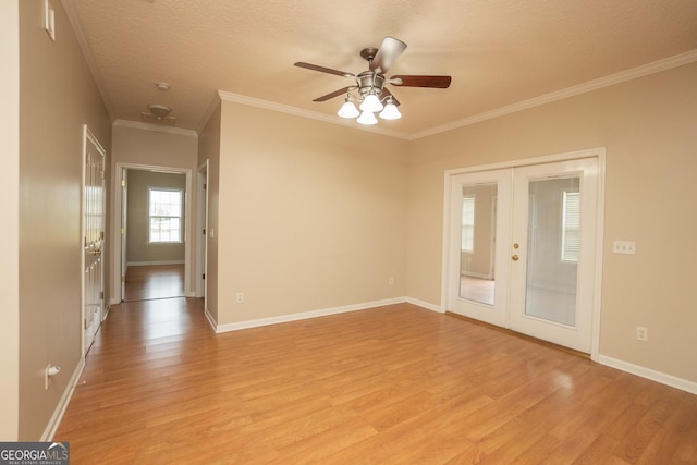 spare room with french doors, light wood-style flooring, ceiling fan, ornamental molding, and baseboards