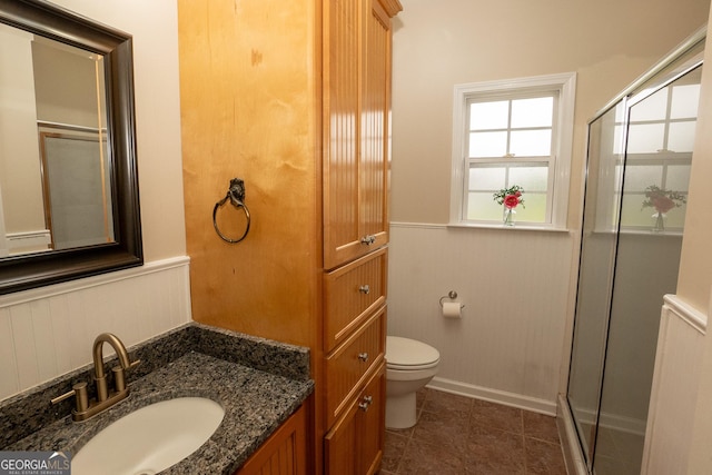 bathroom with a shower stall, toilet, vanity, and tile patterned flooring
