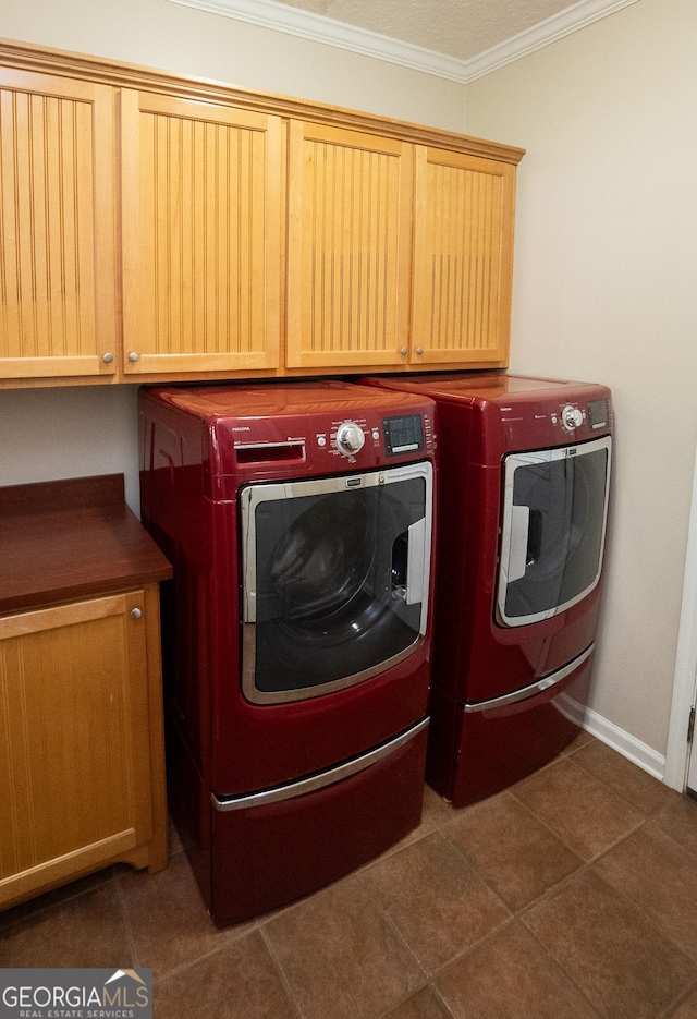 clothes washing area featuring cabinet space, washer and clothes dryer, crown molding, and baseboards