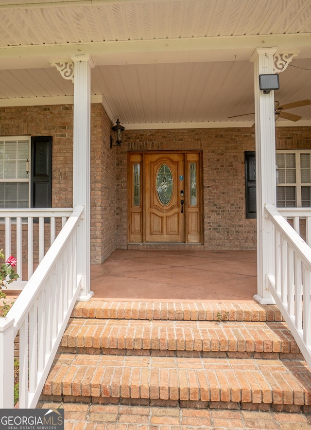 entrance to property featuring covered porch and brick siding