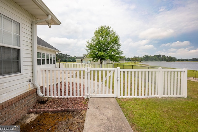 view of yard featuring a water view and a gate