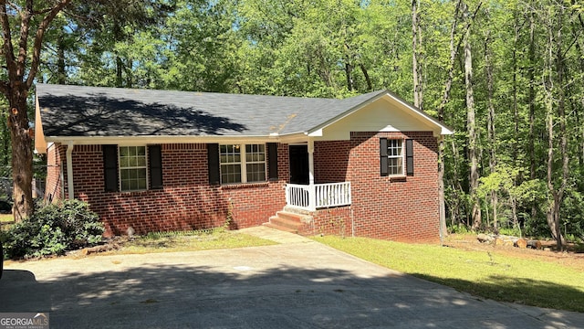 bungalow-style home featuring brick siding, roof with shingles, driveway, and a front yard