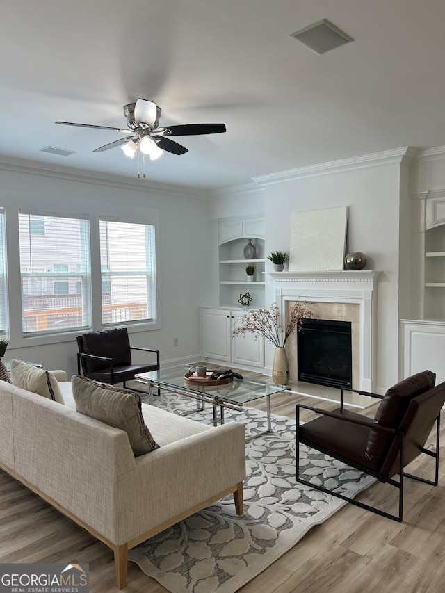 4540 Cold Spring Ct, Cumming, GA 30041 - living room with built in features, ornamental molding, a ceiling fan, wood finished floors, and a premium fireplace