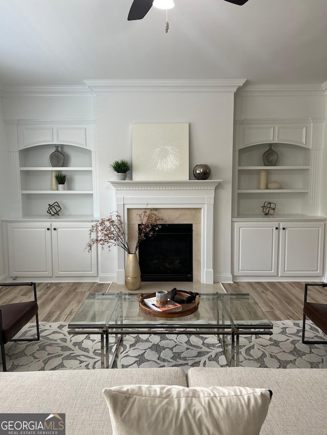 4540 Cold Spring Ct, Cumming, GA 30041 - living room with ornamental molding, light wood-style flooring, ceiling fan, a fireplace, and built in shelves