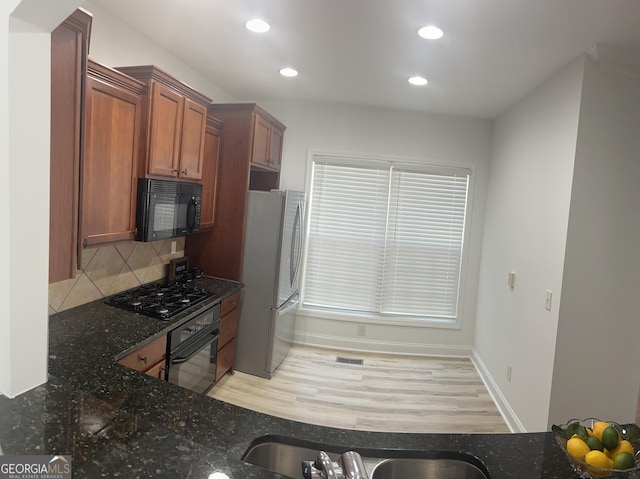 4540 Cold Spring Ct, Cumming, GA 30041 - kitchen featuring black appliances, dark stone countertops, recessed lighting, brown cabinets, and decorative backsplash