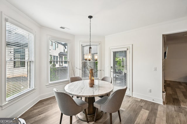 3991 Perry Pass, Lithonia, GA 30038 - dining space featuring a chandelier, wood finished floors, ornamental molding, and healthy amount of natural light
