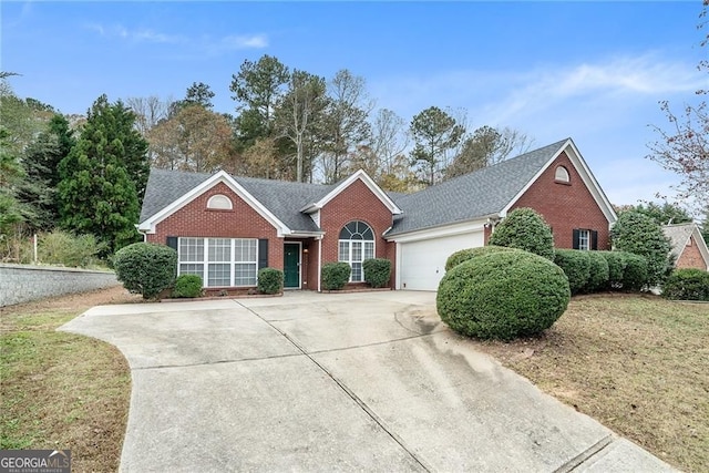 5981 Williamsport Dr, Flowery Branch, GA 30542 - view of front of home featuring brick siding, concrete driveway, a garage, and roof with shingles