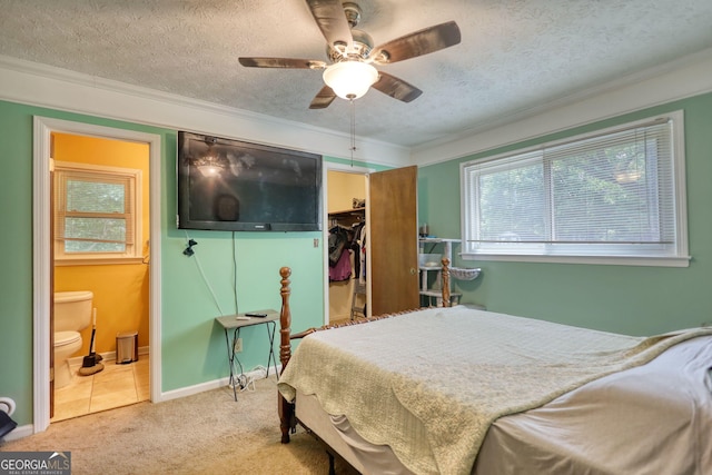 2368 Ellis Ct, Snellville, GA 30078 - carpeted bedroom featuring crown molding, a walk in closet, a textured ceiling, a closet, and ensuite bath