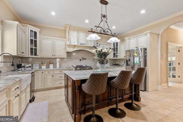 11 Main St, Newnan, GA 30263 - kitchen featuring appliances with stainless steel finishes, arched walkways, light stone counters, a sink, and backsplash