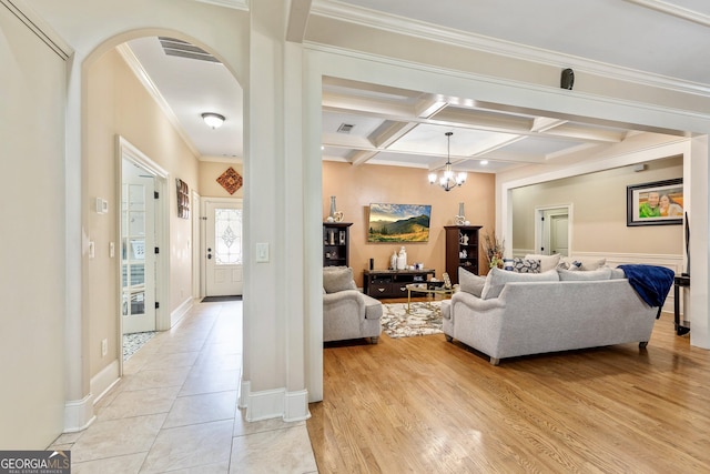 11 Main St, Newnan, GA 30263 - living area featuring coffered ceiling, arched walkways, crown molding, beam ceiling, and a chandelier