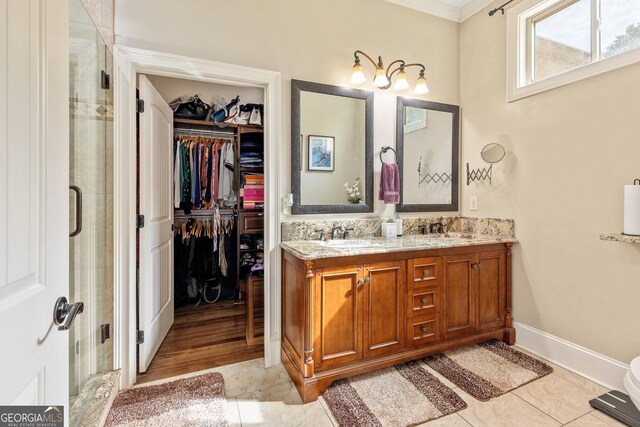 11 Main St, Newnan, GA 30263 - bathroom featuring a stall shower, double vanity, a walk in closet, ornamental molding, and baseboards