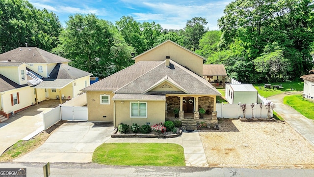 11 Main St, Newnan, GA 30263 - view of front facade featuring a gate, a porch, stucco siding, driveway, and fence
