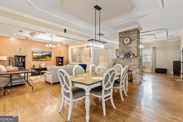 11 Main St, Newnan, GA 30263 - dining area featuring light wood finished floors, crown molding, a chandelier, coffered ceiling, and a fireplace