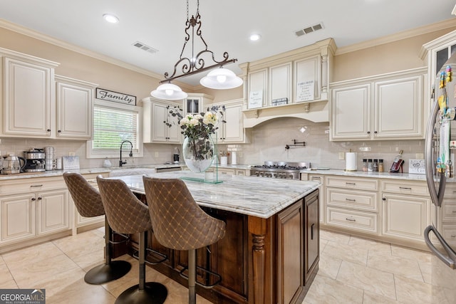 11 Main St, Newnan, GA 30263 - kitchen with a sink, a center island, light stone counters, decorative backsplash, and cream cabinetry