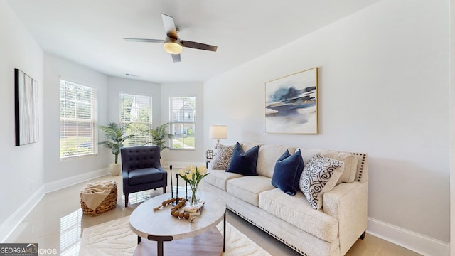 living area with ceiling fan and baseboards