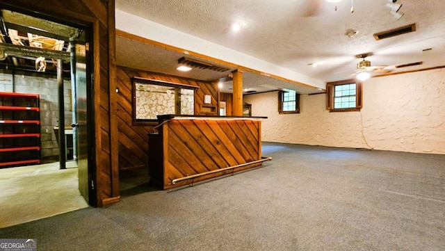 indoor dry bar featuring ceiling fan, carpet floors, and a textured ceiling