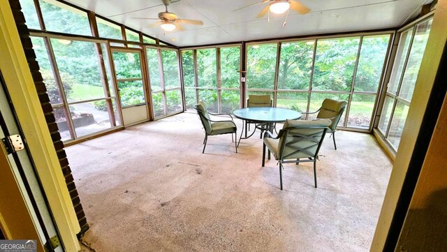 sunroom / solarium featuring ceiling fan and outdoor dining area