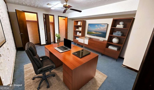 carpeted office space with built in features, a textured ceiling, baseboards, and ceiling fan
