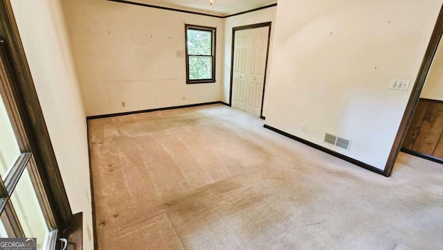 unfurnished bedroom with carpet flooring, baseboards, crown molding, and a closet