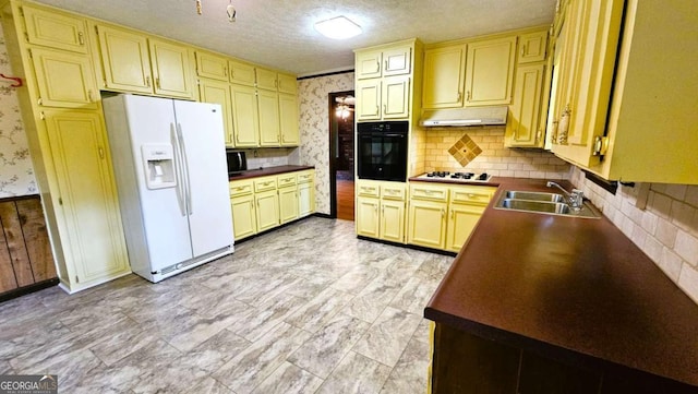 kitchen featuring white appliances, a sink, under cabinet range hood, dark countertops, and backsplash