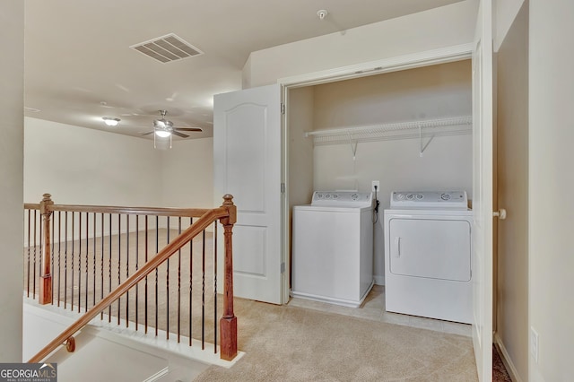 laundry room featuring washing machine and dryer, ceiling fan, and light colored carpet