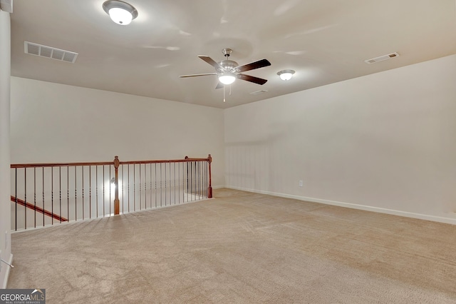 spare room featuring ceiling fan, carpet floors, and baseboards
