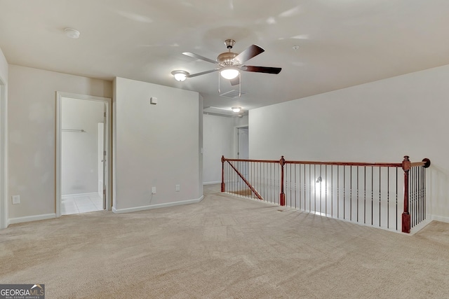 carpeted spare room featuring a ceiling fan, baseboards, and a smoke detector