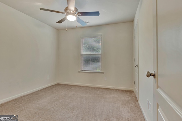 spare room with light colored carpet, ceiling fan, and baseboards