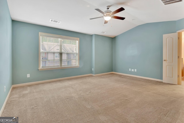 carpeted empty room featuring vaulted ceiling, a ceiling fan, and baseboards
