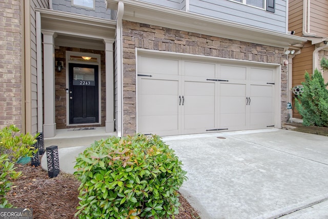 property entrance featuring a garage and concrete driveway