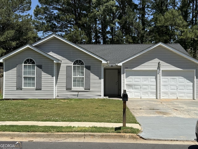 view of front facade featuring an attached garage, driveway, a front yard, and a shingled roof