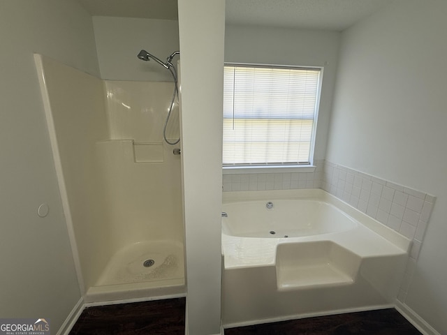 full bath featuring wood finished floors, a bath, and a shower