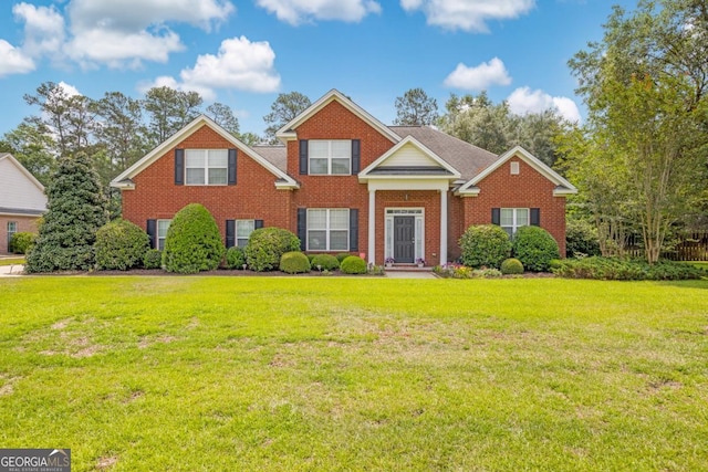 view of front of home with a front lawn and brick siding