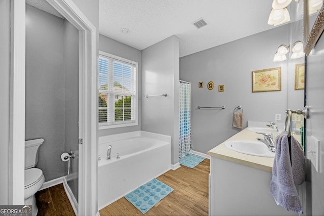 full bathroom with toilet, wood finished floors, a bath, and baseboards