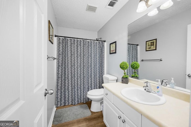 full bath featuring wood finished floors, toilet, vanity, a textured ceiling, and curtained shower