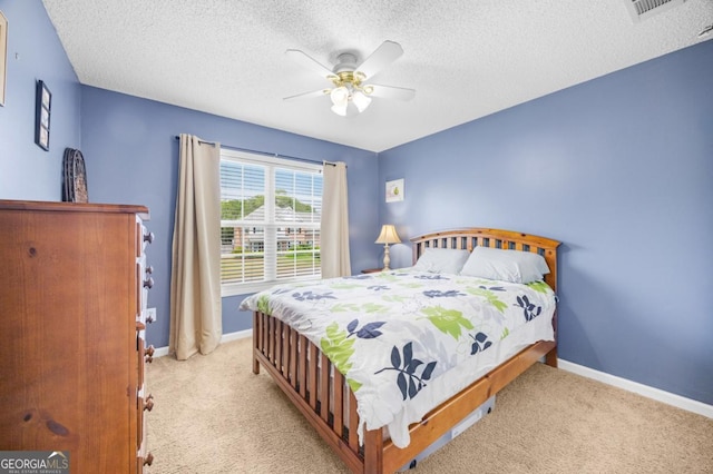 bedroom with carpet floors, baseboards, a ceiling fan, and a textured ceiling