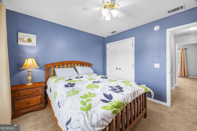 carpeted bedroom with a closet, baseboards, a ceiling fan, and attic access