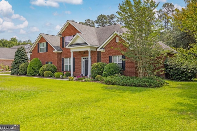 view of front of home with a front lawn and brick siding