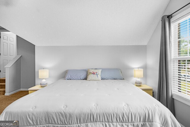 bedroom featuring carpet, baseboards, and vaulted ceiling
