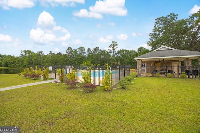 view of yard with a community pool and a ceiling fan