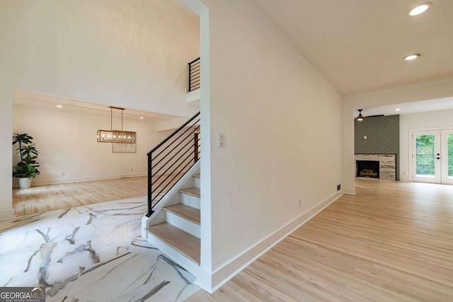 4 Bentley Trace Mnr, Atlanta, GA 30327 - staircase with wood finished floors, a large fireplace, recessed lighting, high vaulted ceiling, and a chandelier