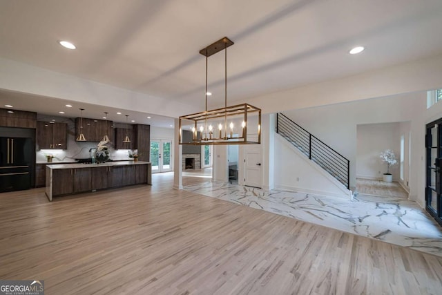 4 Bentley Trace Mnr, Atlanta, GA 30327 - unfurnished living room with light wood-type flooring, a fireplace, recessed lighting, and stairway